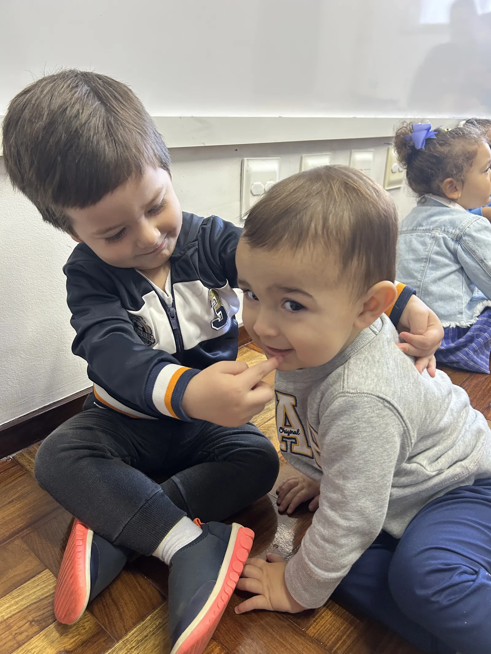 Aluno cuidando de um colega mais novo durante o lanche