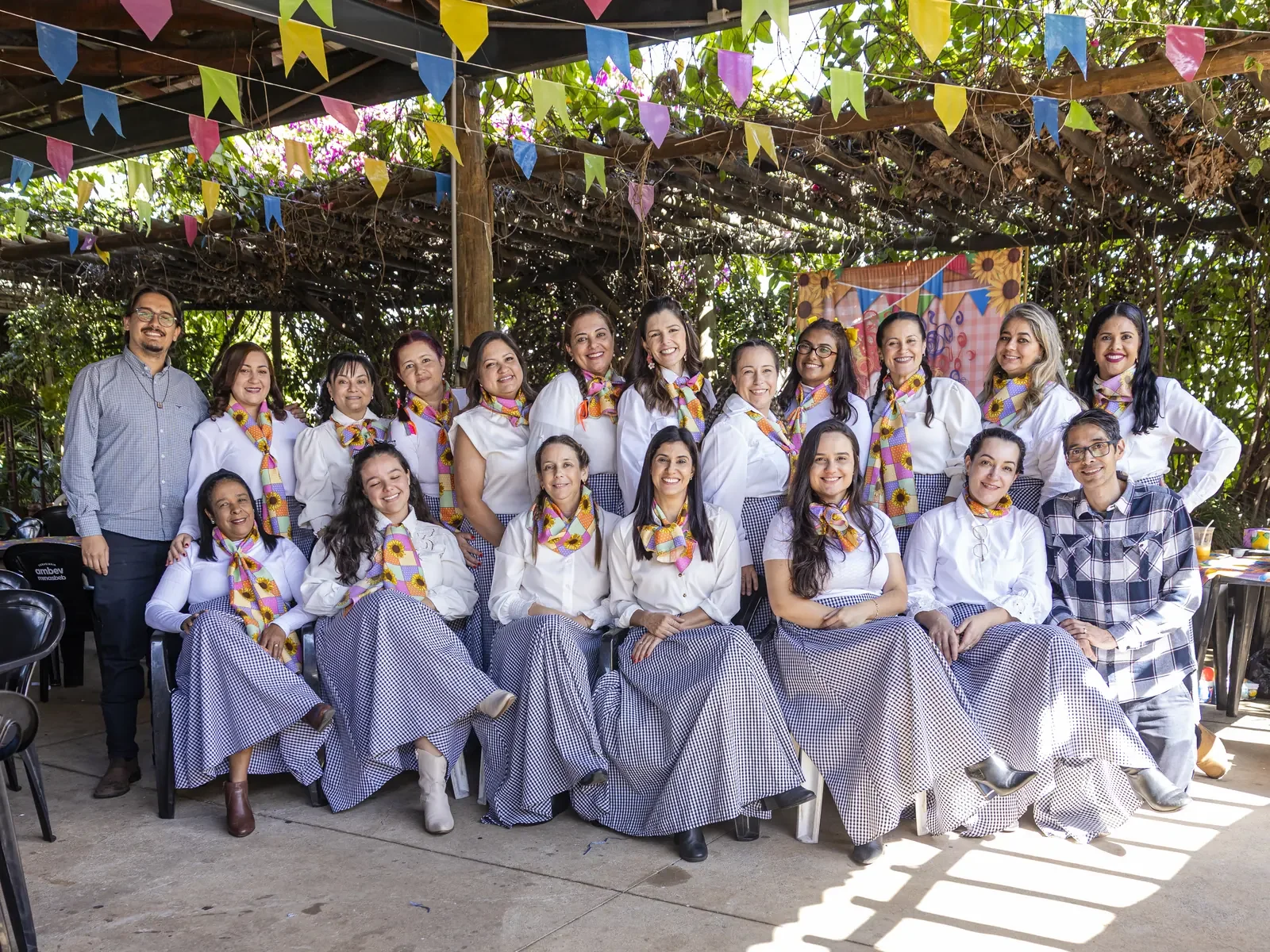 Equipe do Colégio Açucena reunida e sorridente na festa junina da escola